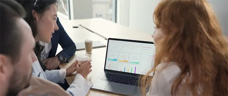 Team reviewing search performance data on a laptop screen during a strategy session